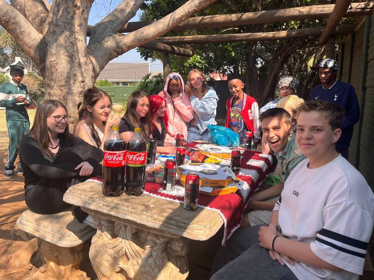 Learners smiling around the picnic table at St. Ronald's Homeschool